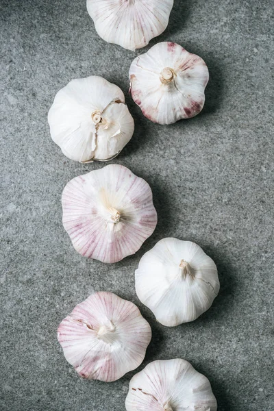 Row Ripe Whole Garlic Bulbs Grey Background — Free Stock Photo