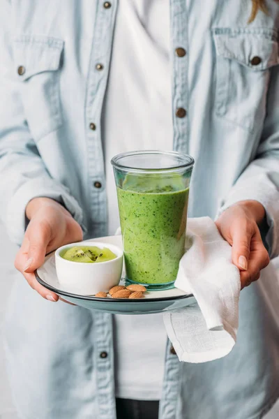 Ženské Ruce Drží Desku Kiwi Ovoce Mandle Sklo Zelené Smoothie — Stock fotografie