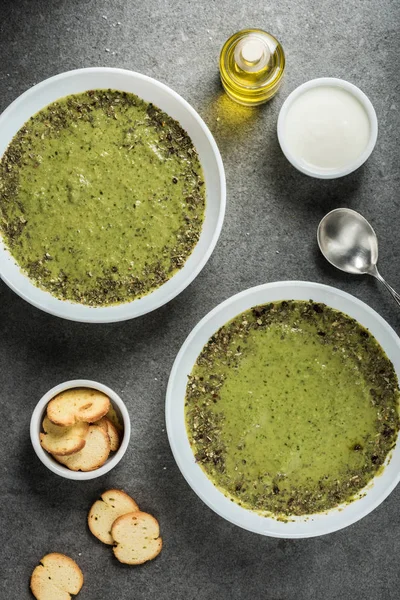 Top view of two bowls with green spinach soup, sour cream, oil and croutons — Stock Image Top View Two Bowls Green Spinach Soup Sour Cream Oil Royalty Free Stock Photos