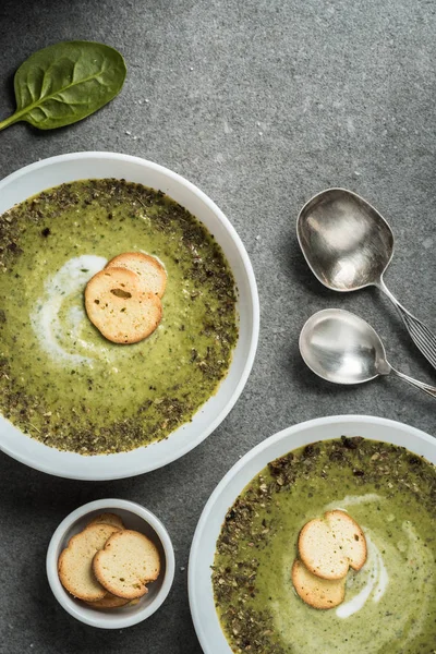 Top view of two bowls with green creamy spinach soup and croutons — Stock Image Top View Two Bowls Green Creamy Spinach Soup Croutons Royalty Free Stock Images