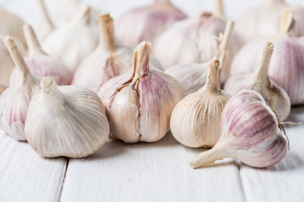 bulbs of garlic on white rustic wood table