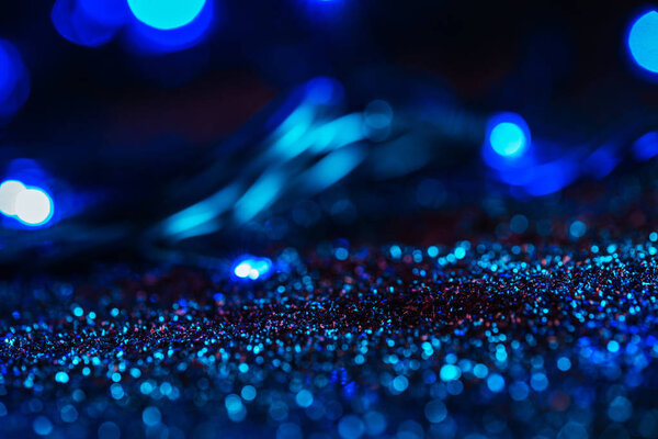 abstract glowing background with blue glitter and bokeh