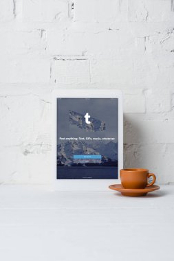 tumblr uygulama ve kahve yakınındaki beyaz tuğla duvar ile dijital tablet