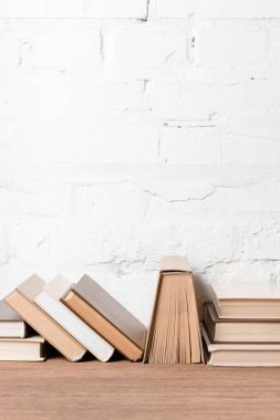 hardcovers kitaplarla yakınındaki beyaz tuğla duvar ahşap tablo  