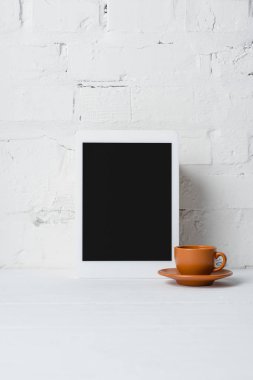 boş ekran ve kahve yakınındaki beyaz tuğla duvar ile dijital tablet yakından görmek