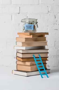 kitap, küçük bir adım merdiven ve cam bir kavanoz ile tasarruf ve yazıt kitaplar