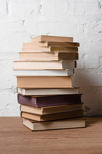 close-up view of pile of books on wooden table