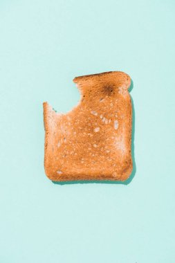 top view of bitten crunchy toast on blue surface clipart