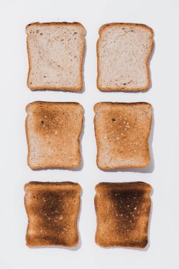 top view of rows of toasts in various roast stages on white surface clipart