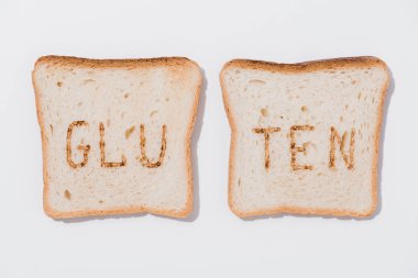 top view of slices of bread with burned gluten sign on white surface clipart