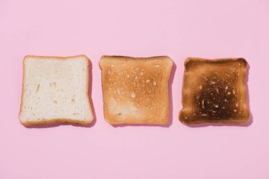 top view of toasts in various roast stages on pink surface clipart