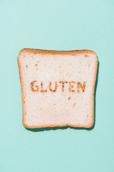 top view of row of bread slice with gluten sign on blue surface
