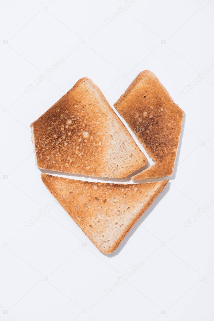 top view of heart shape made of toast on white surface