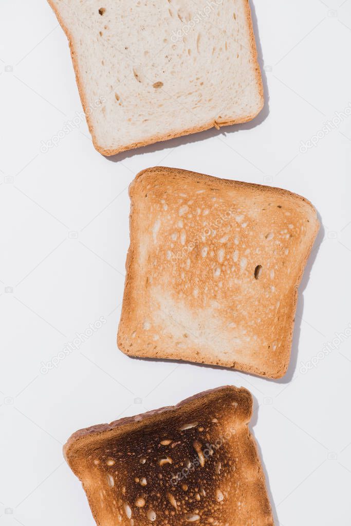 top view of toasts in various roast stages on white surface