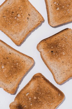 Beyaz yüzey üzerinde dökülen lezzetli çıtır tost üstten görünüm