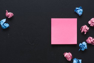 en çok dağınık pembe ve mavi buruşuk Kağıt topları ile yapışkan not görünümünü siyah arka plan üzerine, farklı kavram düşünüyorum