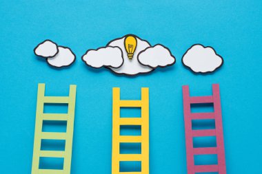 top view of cardboard ladders with light bulb and clouds on blue background, ideas concept clipart