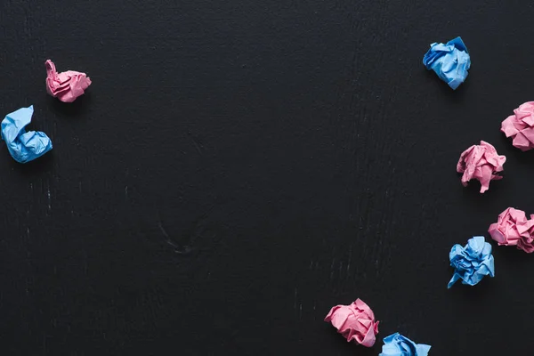 Bovenaanzicht Van Verspreide Roze Blauwe Verfrommeld Papier Ballen Zwarte Achtergrond — Stockfoto