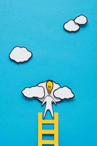 top view of cardboard man with light bulb head climbing ladder on blue background, ideas concept