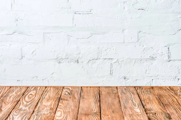 白いレンガの壁と素朴な木製のテーブル — ストック写真