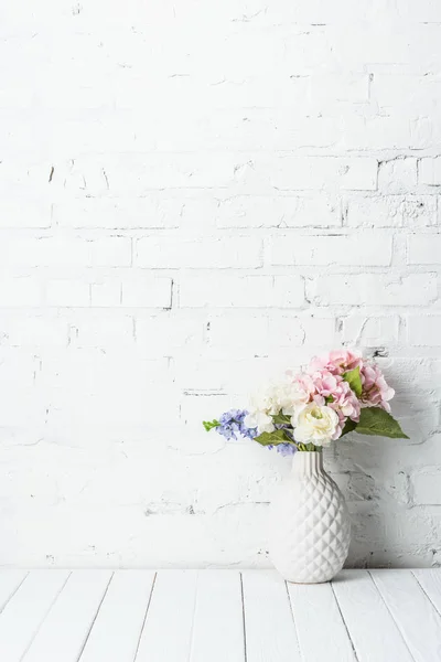 レンガの壁の近くの素朴な木製テーブルの上の花の花束と陶製の花瓶 — ストック写真