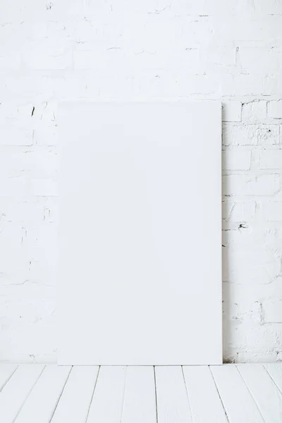 レンガの壁の近くの白い木製のテーブルで空白のプラカード — ストック写真