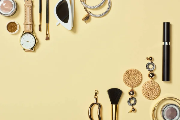 Top view of watch, sunglasses, eyeshadow, cosmetic brushes, bracelets, earrings and mascara on yellow background — Stock Image Top View Watch Sunglasses Eyeshadow Cosmetic Brushes Bracelets Earrings Mascara Stock Image
