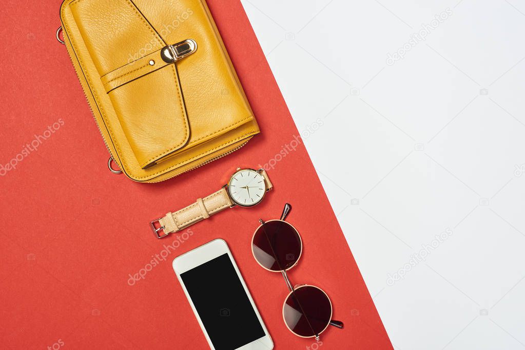 Top view of  yellow bag, sunglasses, smartphone, watch with copy space 
