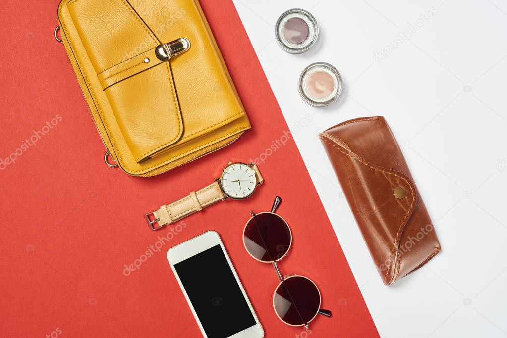 Top view of bag, sunglasses, eyeshadow, smartphone, watch and case 