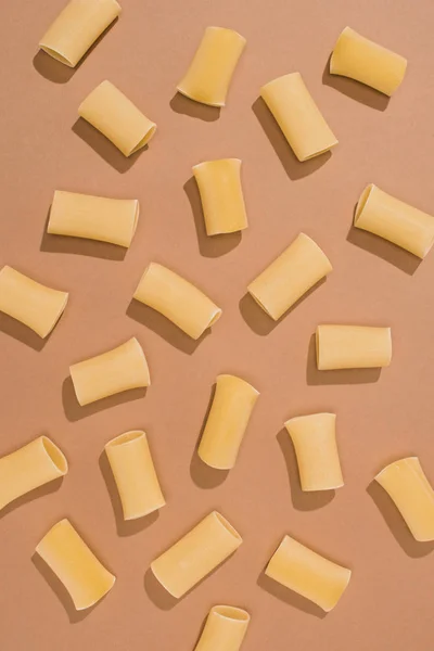 Draufsicht auf verschüttete Pasta auf beiger Oberfläche — Stockfoto