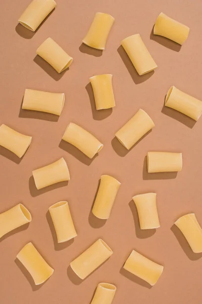 Top view of pasta spilled on beige surface — Stock Photo