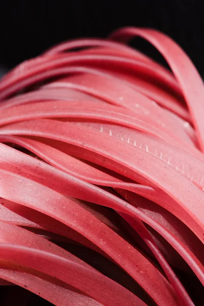 Primo piano di spaghetti rossi crudi su nero — Foto stock