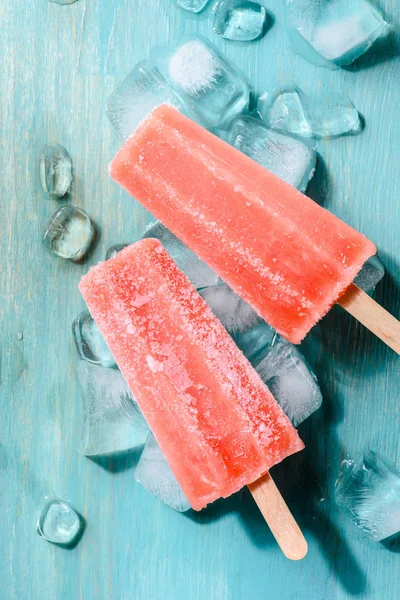 Delicious frozen sorbet on wooden background with ice cubes — Stock Photo