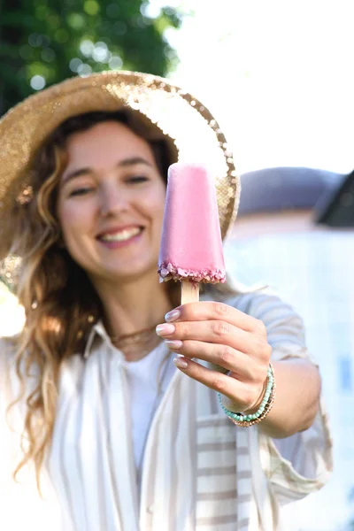 Pop de hielo de fruta en la mano de la mujer joven - foto de stock