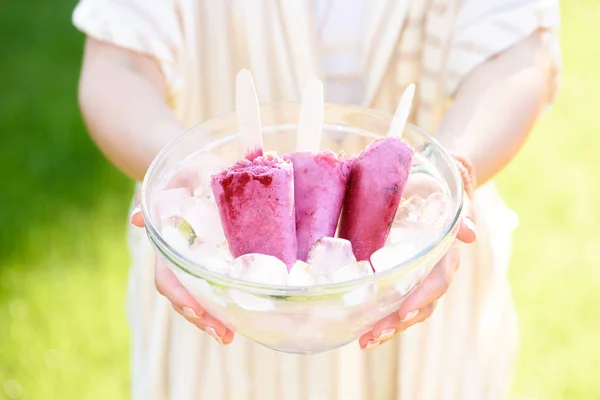 Woman holding bowl with berry ice pops — Stock Photo