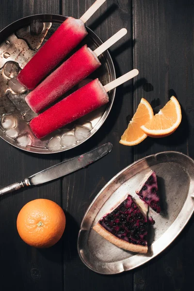 Süßfrucht-Eis mit Orangen und Beerenkuchen auf Holzgrund — Stockfoto