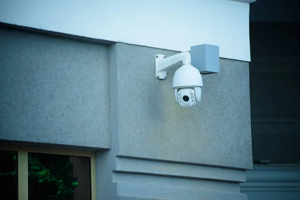 Vista de cerca de la cámara de seguridad en la fachada del edificio gris - foto de stock