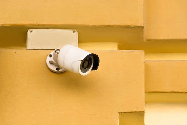 Vista de cerca de la cámara de seguridad en la fachada del edificio amarillo - foto de stock