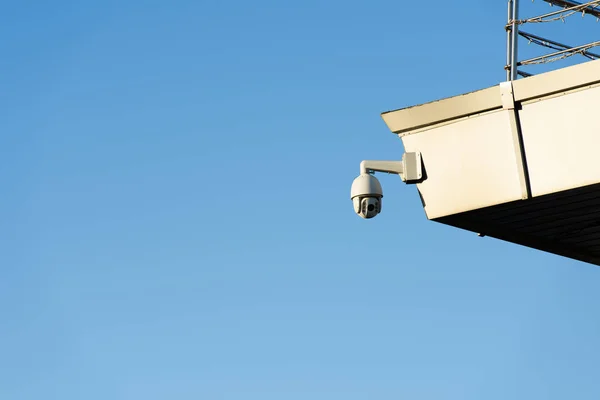 Vue rapprochée de la caméra de sécurité sur la façade du bâtiment avec un ciel bleu clair — Photo de stock