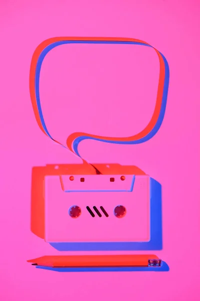 Toned pink picture of pencil and retro audio cassette with speech bubble — Stock Photo