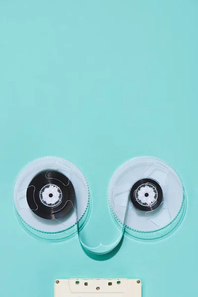 Top view of arranged vintage audio cassette and tape isolated on blue — Stock Photo