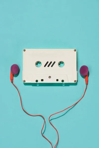 Plano con cassette de audio retro blanco y auriculares aislados en azul - foto de stock