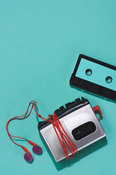 Flat lay with retro audio cassette, cassette player and earphones isolated on blue — Stock Photo