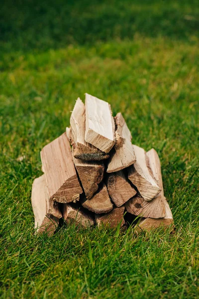 Pile of firewood on green grass in park — Stock Photo