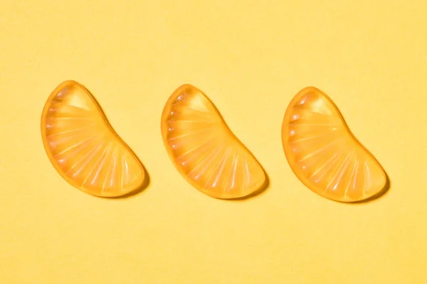 Top view of gummy orange candies on yellow — Stock Photo