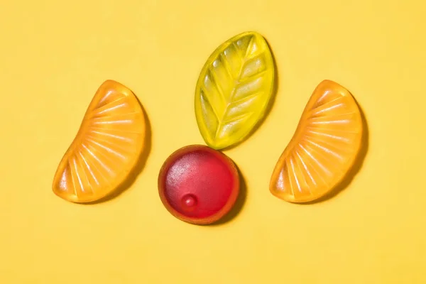 Top view of tasty gummy fruits on yellow surface — Stock Photo
