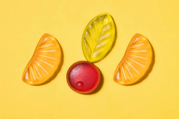 Blick von oben auf leckere Gummibärchen auf gelber Oberfläche — Stockfoto