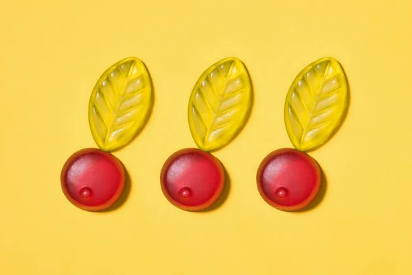 Top view of gummy cherries on yellow surface — Stock Photo