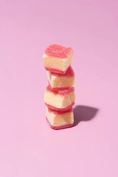 Pila de dulces caramelos de goma en la superficie de color rosa - foto de stock