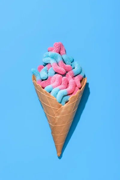 Top view of delicious gummy worms in waffle cone on blue — Stock Photo